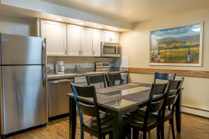 a kitchen with a table with chairs and a refrigerator at Glenwood Springs Cedar Lodge in Glenwood Springs