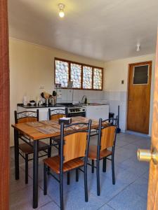 a kitchen with a wooden table and chairs in a room at hostal casa talitha in San Pedro de Atacama