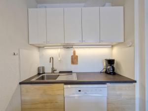 a kitchen with white cabinets and a sink at Appartement spacieux au centre, balcon, proche pistes, 6 pers - FR-1-425-229 in Arâches-la-Frasse +11 photos