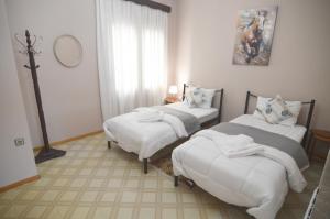 two beds in a room with a cross on the wall at Konstantina's Sky View in Kastoria