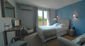 a bedroom with a bed and a desk and a television at Hotel Santa Maria in Saint-Florent