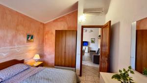 a bedroom with a bed and a living room at Appartamento Quadrifoglio in Castelsardo