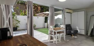a living room with a table and chairs and a patio at Villa Rosen at Ramat Hahayal TLV in Tel Aviv