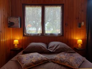 una camera da letto con un letto con due cuscini e una finestra di Chalet cosy et romantique avec terrasse en Eure-et-Loir - FR-1-581-148 a Châteaudun Altre 23 foto
