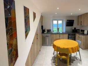a kitchen and dining room with a yellow table and chairs at Gîte cosy avec WIFI et parking, proche nature - FR-1-589-781 in Le Clerjus