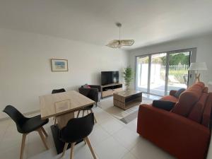 ein Wohnzimmer mit Sofa, Stühlen und einem Tisch in der Unterkunft Royan T3 Moderne - Bord De Mer - 6 Pers, Parking, Terrasse - FR-1-738-35 in Royan