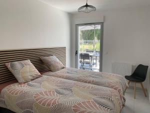 ein Schlafzimmer mit einem großen Bett und einem Stuhl in der Unterkunft Royan T3 Moderne - Bord De Mer - 6 Pers, Parking, Terrasse - FR-1-738-35 in Royan