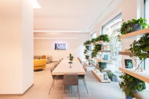 a table and chairs in a room with plants at RELSTAY - De Angeli in Milan