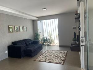 a living room with a blue couch and a rug at Casa Bela no Rita Vieira in Campo Grande