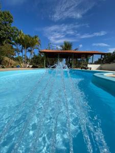 a pool with water shooting up into the air at Chácara Buíque&Xique in Jarinu