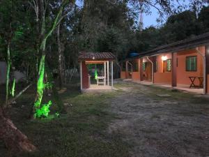 una casa con luz verde en el patio en Casa para temporada em Peruíbe, en Peruíbe