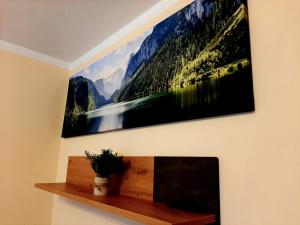 un tableau accroché au mur au-dessus d'une cheminée dans l'établissement Susis Apartment Altenmarkt, à Altenmarkt im Pongau