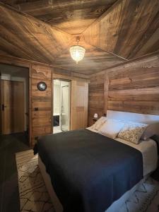 a bedroom with a bed with a wooden ceiling at Confort et Proximité in Megève