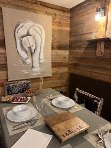 a dining room with a table with plates and glasses at Confort et Proximité in Megève