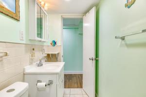 a white bathroom with a sink and a mirror at Walk to Shore Atlantic Beach Condo with Pool Access in Atlantic Beach +17 photos