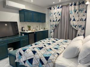 a bedroom with a bed and a kitchen with blue cabinets at Danda moon Pyramids Hotel in Cairo
