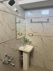 a bathroom with a sink and a mirror at Western Royal Homes in Bengaluru