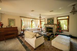 a living room with a christmas tree and a piano at Araucária Lodge - 800 metros do Capivari in Campos do Jordão