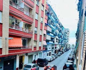 a street with cars parked on the side of a building at Piso Lorena Playa 1min walk in Puerto de Sagunto