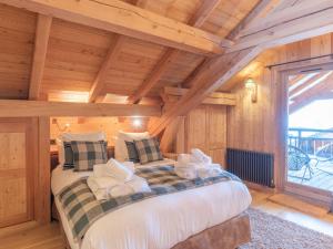 a bedroom with a large bed in a wooden room at Chalet aux pieds des pistes avec spa, sauna et parking - FR-1-645-43 in LʼHuez
