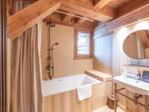 a bathroom with a bath tub and a sink at Chalet aux pieds des pistes avec spa, sauna et parking - FR-1-645-43 in LʼHuez +8 photos