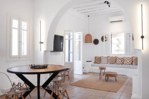 a white living room with a table and a couch at Mykonian Style w Shared Pool Houses 8 & 9 in Ornos
