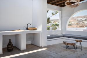 a kitchen with a counter and a table and a window at Mykonian Style w Shared Pool Houses 8 & 9 in Ornos