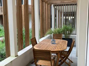 a wooden table and chairs on a porch at Appartement Neuf avec Terrasse au Coeur de Le Palais - FR-1-418-258 in Le Palais