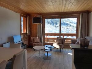 un soggiorno con divano, sedie e una grande finestra di Bel appartement 3 pièces rénové - Méribel, 6 pers, Wi-Fi, garage - FR-1-411-976 a Les Allues