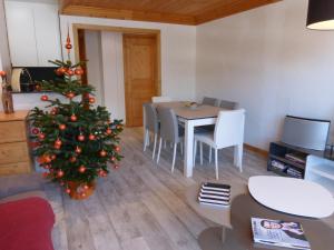 un soggiorno con albero di Natale, tavolo e sedie di Bel appartement 3 pièces rénové - Méribel, 6 pers, Wi-Fi, garage - FR-1-411-976 a Les Allues