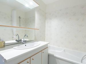 a white bathroom with a sink and a tub at Appartement 6 personnes avec piscine à Peyragudes - FR-1-695-67 in Gouaux-de-Larboust