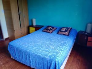 a blue bed with two pillows on top of it at Dimensión moonlight in La Falda
