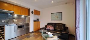 Una sala de estar con un sofá y una cocina. en Ferienwohnung Sternenwald, en Alf 40 fotos más