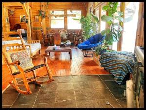 uma sala de estar com cadeiras de baloiço e uma mesa em gite comme un accord em Saint Mathieu Du Parc