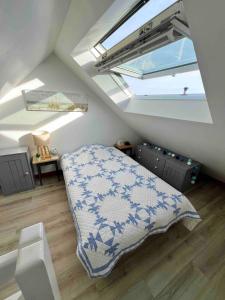 - une chambre mansardée avec un lit et une lucarne dans l'établissement Maison de famille en bord de mer, à Saint-Gildas-de-Rhuys 33 autres photos