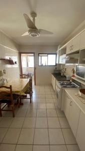 eine Küche mit einem Tisch und einem Herd sowie ein Esszimmer in der Unterkunft Apartamento familiar na Guilhermina in Praia Grande