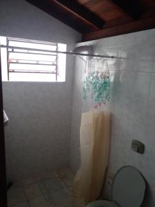 ein Badezimmer mit Dusche, Toilette und Fenster in der Unterkunft Casarão até 8 pessoas 400m mar Bombinhas in Bombinhas + 8 Fotos