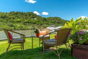 a patio with chairs and a table in the grass at Rizzu Marina Hotel in Balneário Camboriú