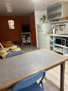 a kitchen with a table and a blue chair at Appartement rénové à Lapte avec terrasse 40 m² in Lapte