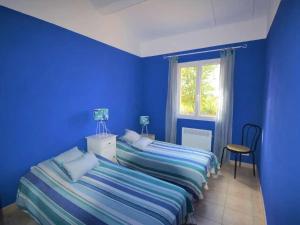 a blue bedroom with two beds and a window at Maison familiale spacieuse avec piscine à Vagnas in Vagnas +21 photos
