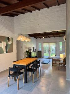 a dining room with a wooden table and chairs at Casa Chalet Ensueños VISTA A LA LAGUNA in Chascomús