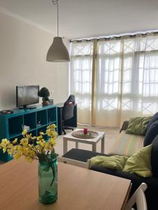 a living room with a vase of flowers on a table at La Casa de la Plaza in Cee