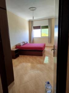 a bedroom with a bed and a window in it at Résidence Nydia in Ras El Ma