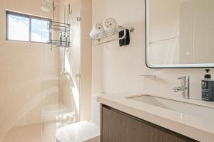 a white bathroom with a sink and a mirror at Palmas de Tamarindo 24B in Tamarindo +13 photos