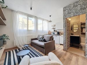 a living room with a couch and a table at Le pétillant champenois in Reims +13 photos