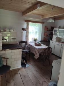 a kitchen with a table and a kitchen with a stove at Roztoczańska Derylówka, domki na Roztoczu in Potoczek
