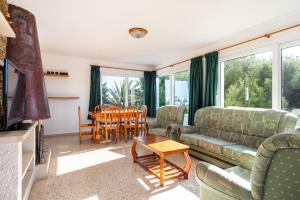 a living room with a couch and chairs and a table at Villa Carmen in Es Mercadal