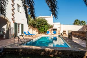 a swimming pool in the backyard of a house at Villa Carmen in Es Mercadal