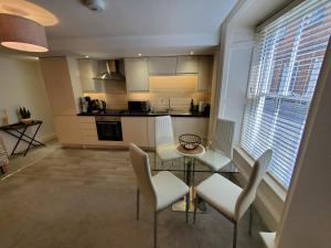 a living room with a table and chairs and a kitchen at Ipswich Town Centre Apartment 8 in Ipswich