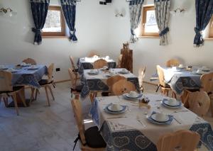 泰塞罗Agritur Maso Piasina的配有桌椅和蓝桌布的房间